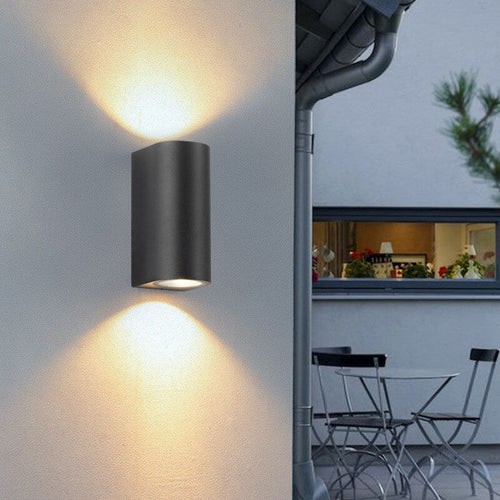 Moderne, enkel, vanntett vegglampe med 2 lyskilder laget av aluminium og glass i sylindrisk design for utendørs bruk.