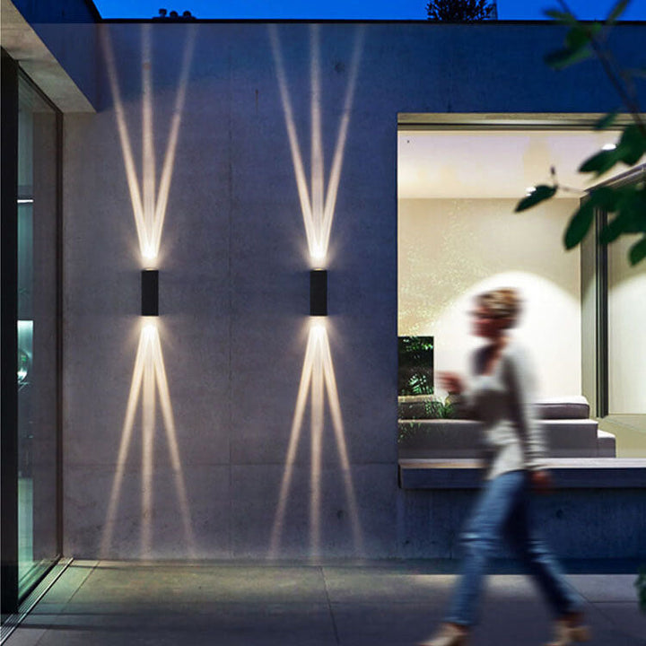 Moderne LED-vegglampe med to lyshoder og aluminiumslinse for utendørs bruk.