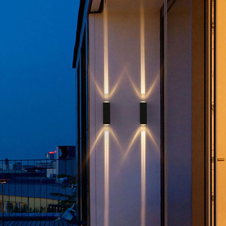 Moderne LED-vegglampe med to lyshoder og aluminiumslinse for utendørs bruk.