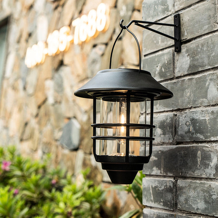 Moderne, retroinspirert, vanntett vegglampe laget av aluminium og glass med solcellefunksjon, sylindrisk, med én flamme, for oppheng på veggen til terrassen.
