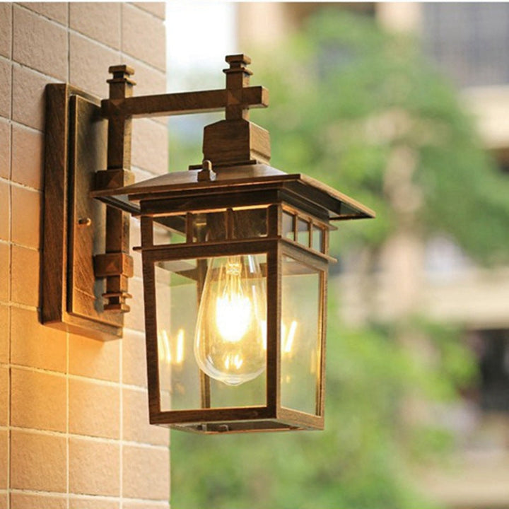 Tradisjonell, rustikk, rektangulær vegglampe laget av støpt aluminium, jern og glass med én lyskilde for hage og terrasse
