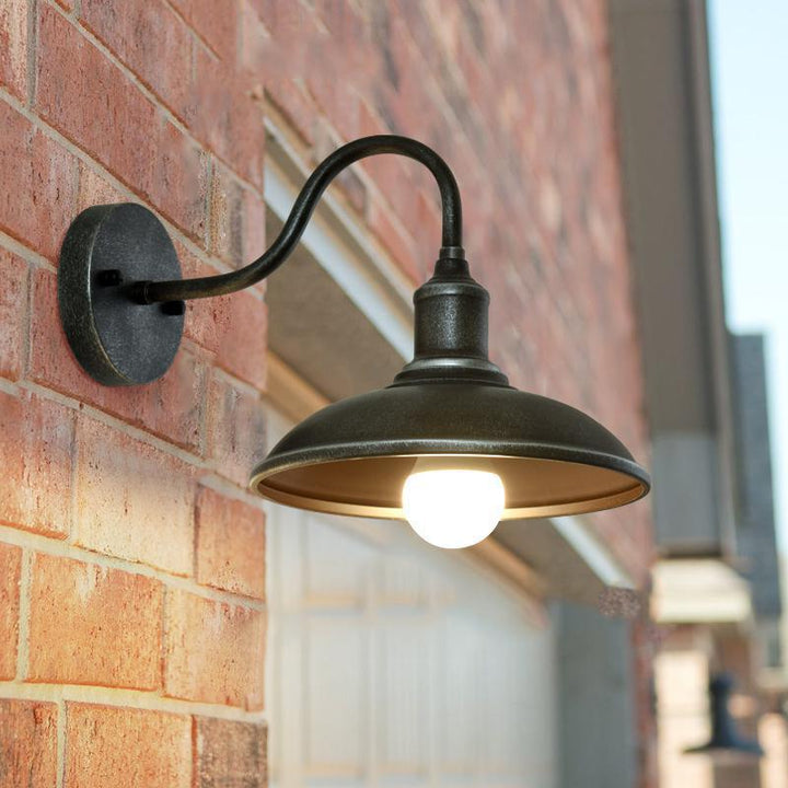 Rund, lokkformet vegglampe med buet jernskjerm og enkeltflammedesign for terrassen
