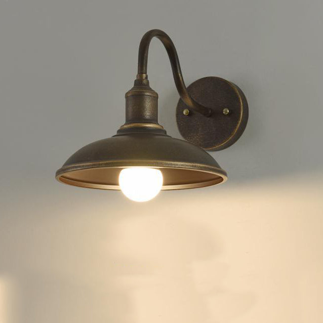 Rund, lokkformet vegglampe med buet jernskjerm og enkeltflammedesign for terrassen