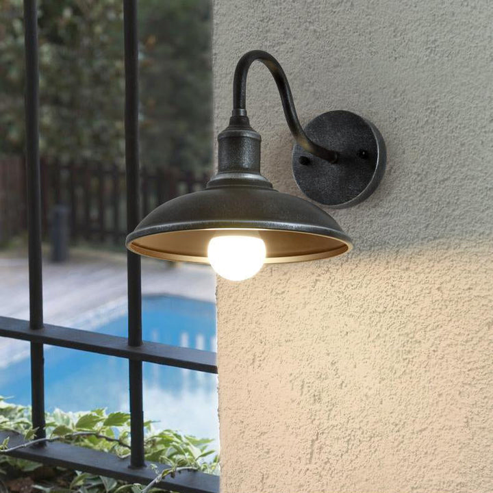 Rund, lokkformet vegglampe med buet jernskjerm og enkeltflammedesign for terrassen