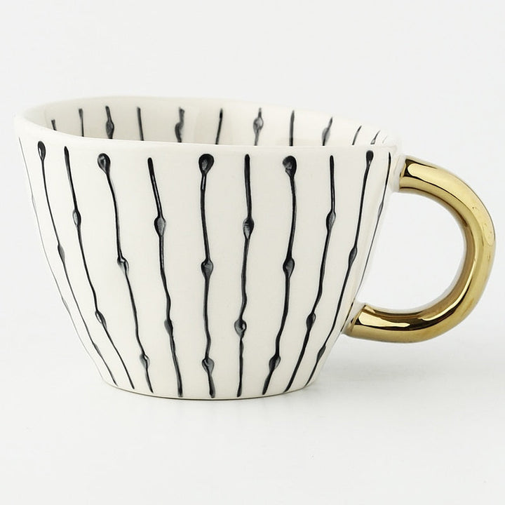 Skanto | Cup med abstrakt geometrisk mønster og gullhåndtak
