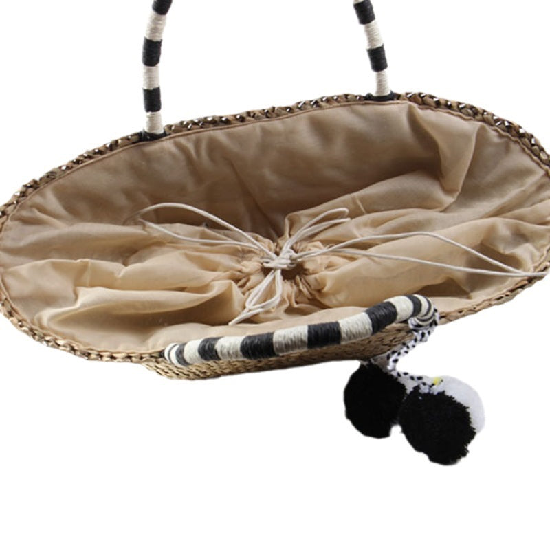 Braided beach bag with decorative pom-poms Skanto