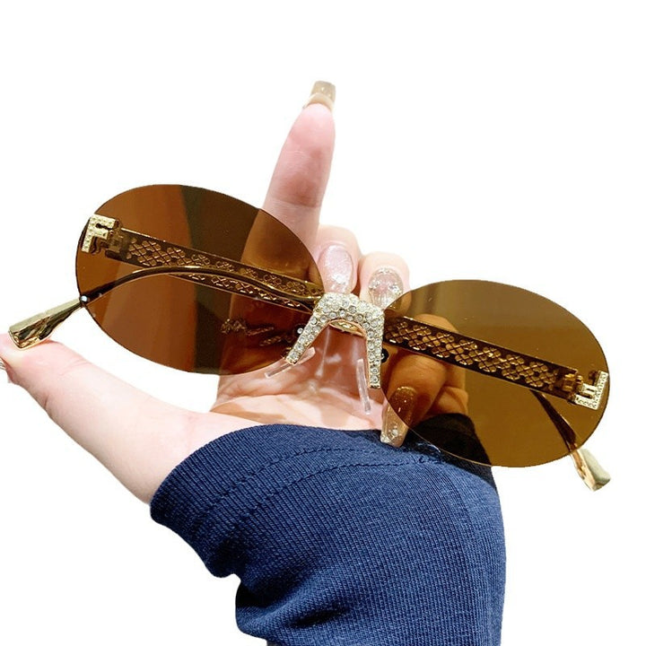 Dame solbrille med glitrende ramme og ovale glass Skanto