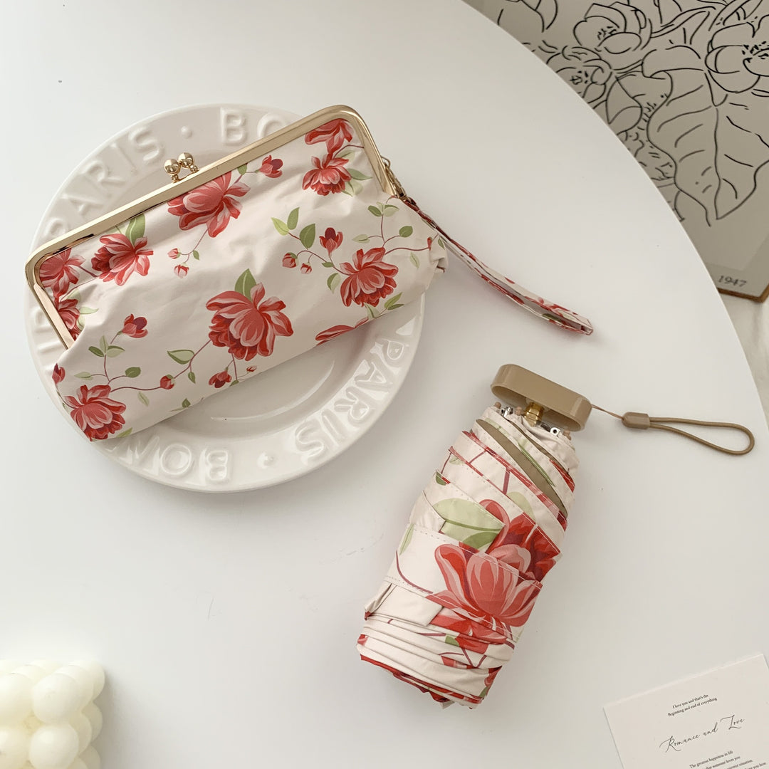 Damer elegant foldeparaply med blomsterdesign og praktisk etui Skanto