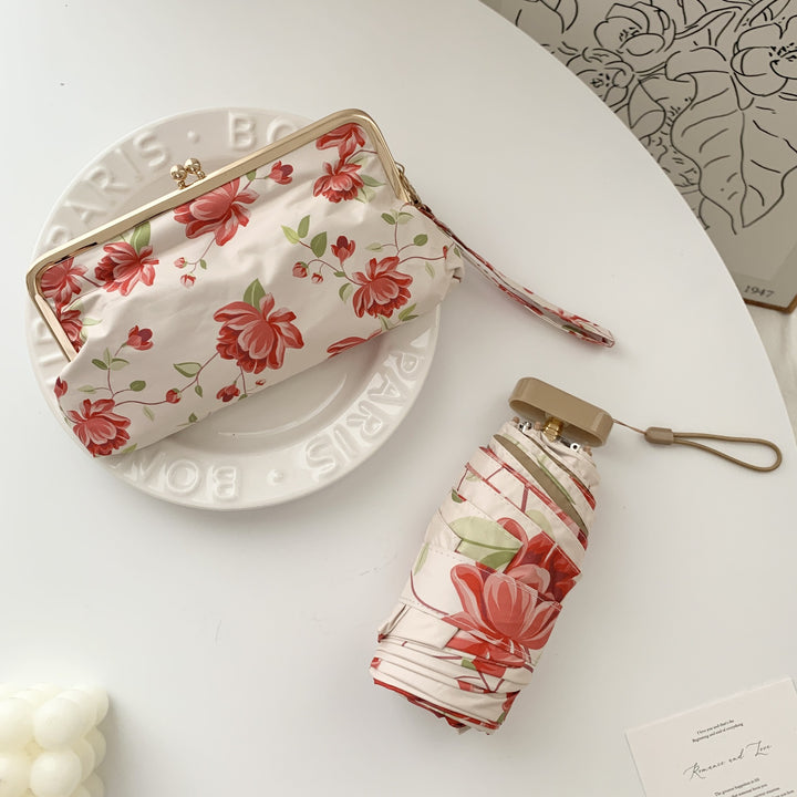 Damer elegant foldeparaply med blomsterdesign og praktisk etui Skanto