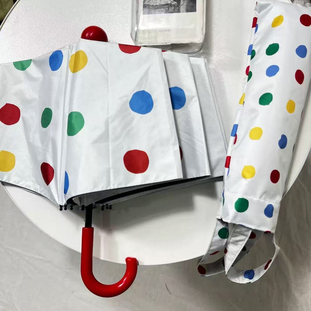 Dame designer Faltregnese med fargerikt prikkemønster Skanto