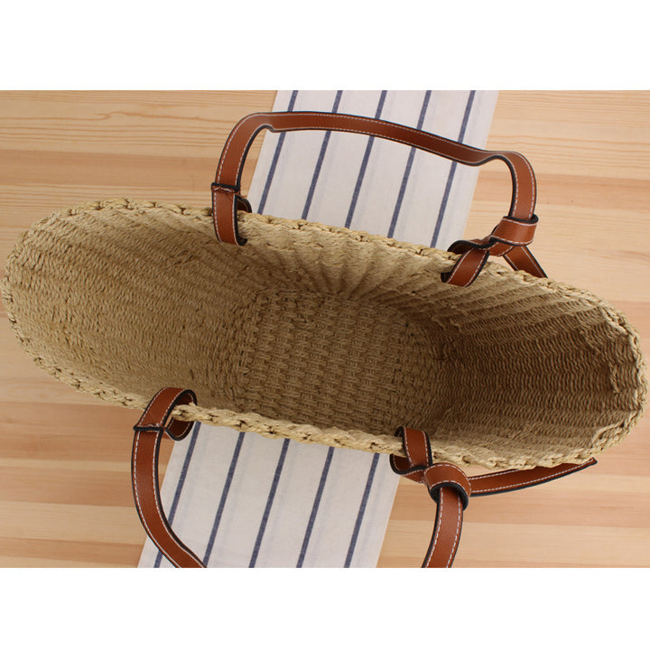 Woven natural material handbag with elegant leather handles Skanto