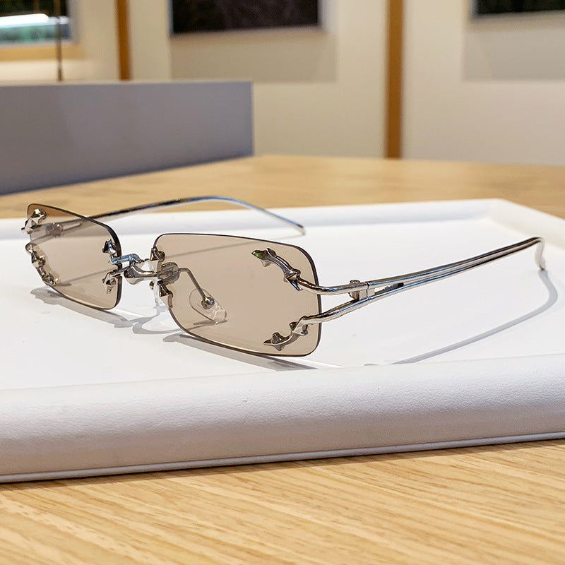 Dame moteriserte solbriller med filigran metallramme og transparente glass Skanto