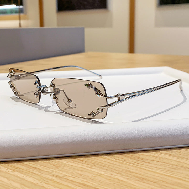 Dame moteriserte solbriller med filigran metallramme og transparente glass Skanto