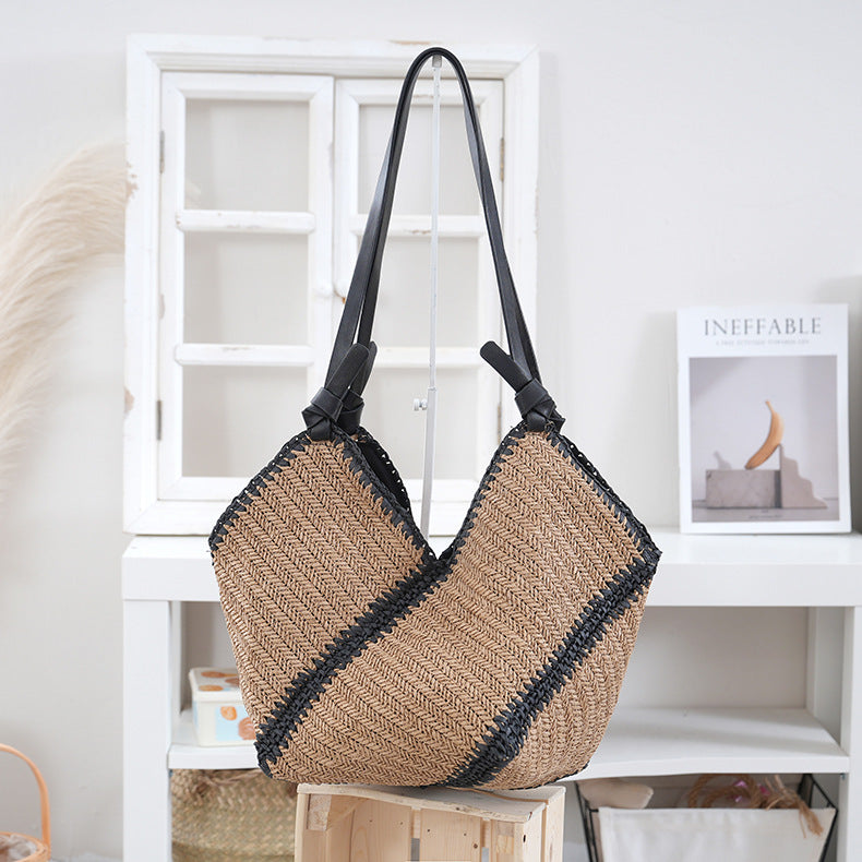Håndveske laget av flettet naturmateriale med kontrasterende lærhåndtak Skanto