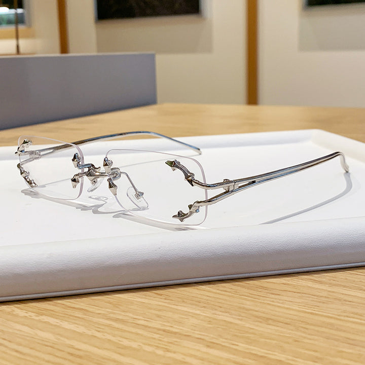 Dame moteriserte solbriller med filigran metallramme og transparente glass Skanto