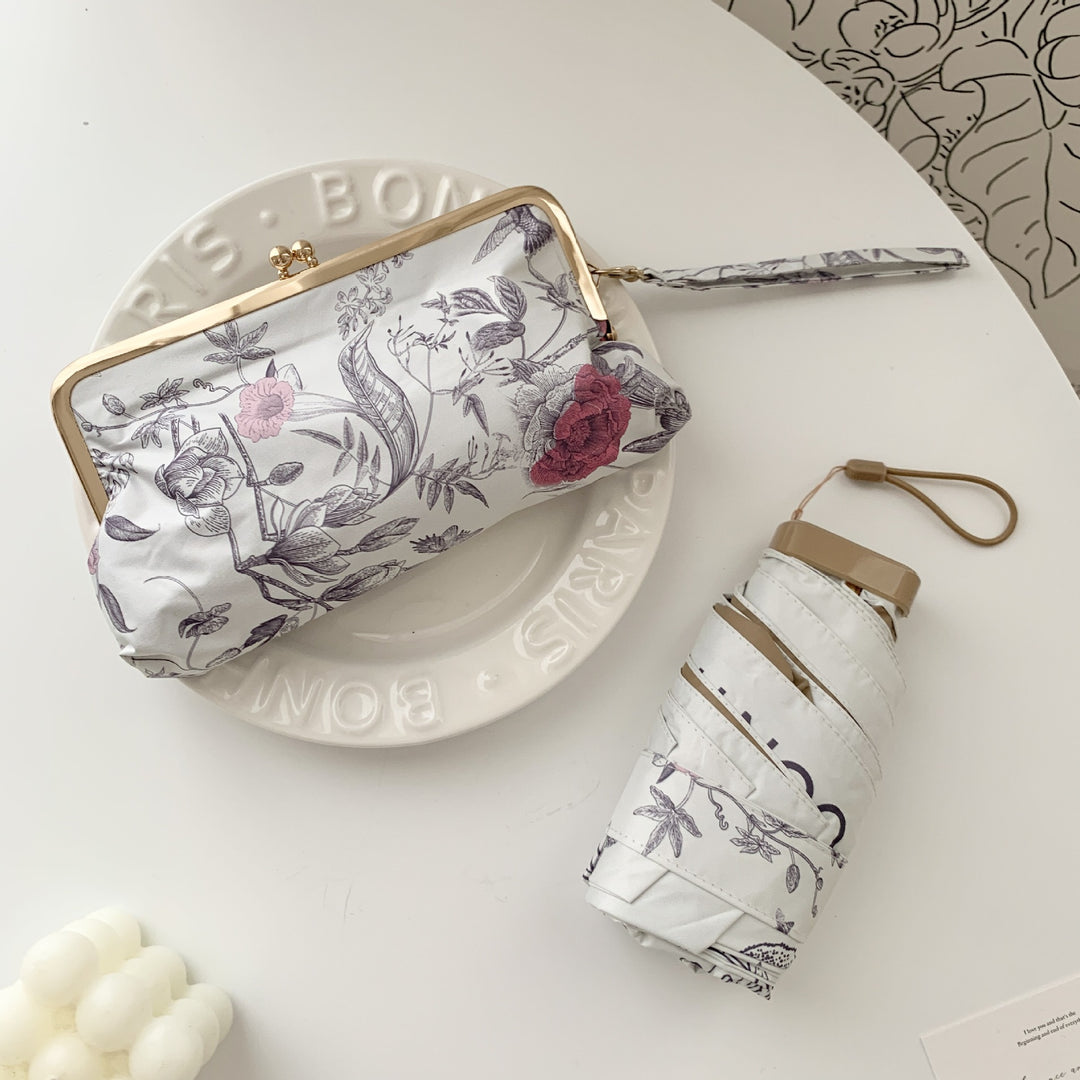 Damer elegant foldeparaply med blomsterdesign og praktisk etui Skanto