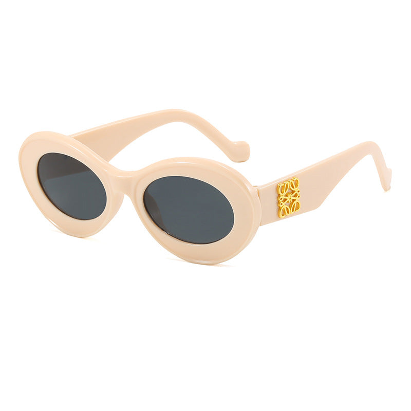 Dame moteriktig solbrille med oval ramme og gullapplikasjoner Skanto