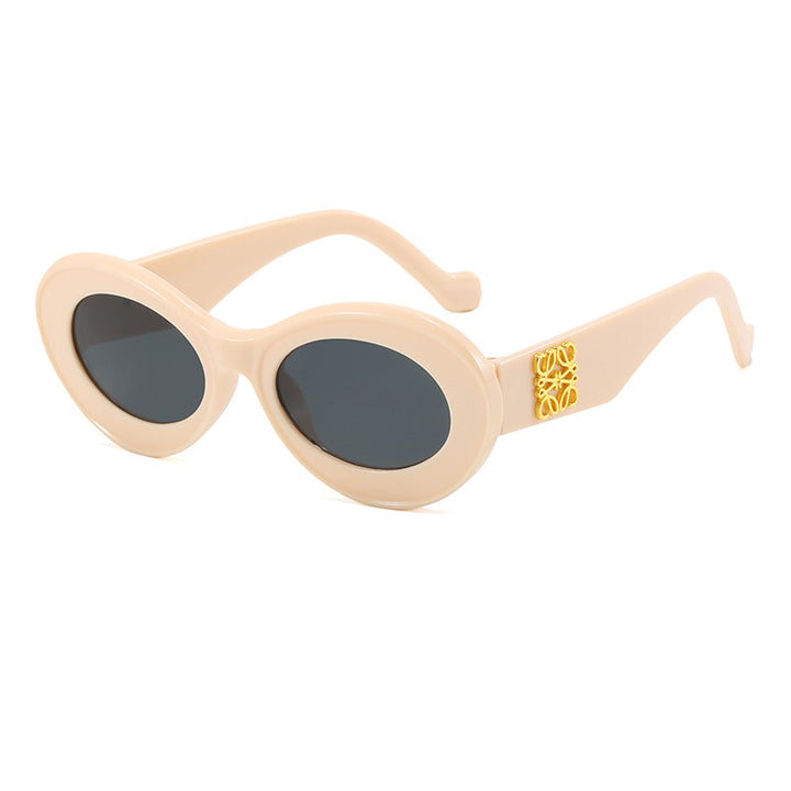 Dame moteriktig solbrille med oval ramme og gullapplikasjoner Skanto