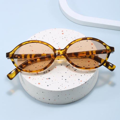 Dame moteriktig solbrille med oval ramme og gyldne detaljer Skanto