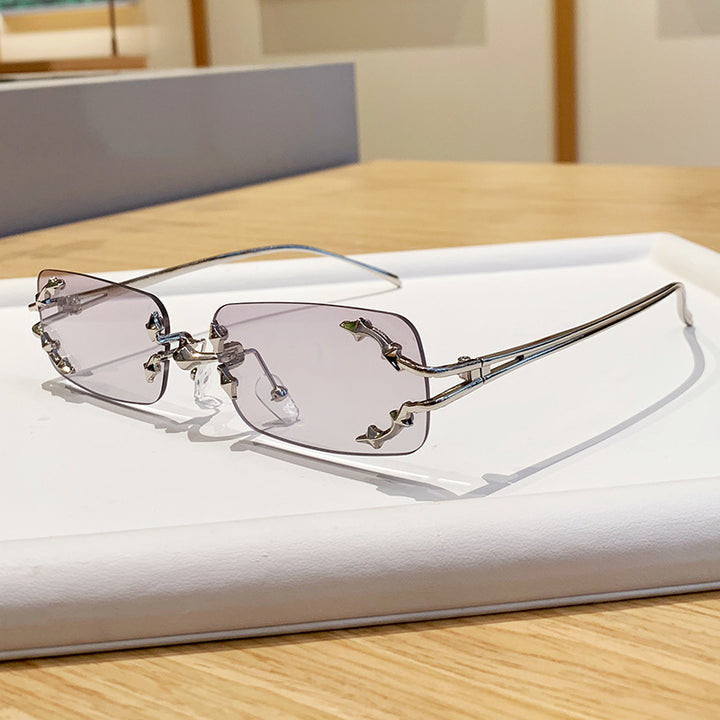 Dame moteriserte solbriller med filigran metallramme og transparente glass Skanto
