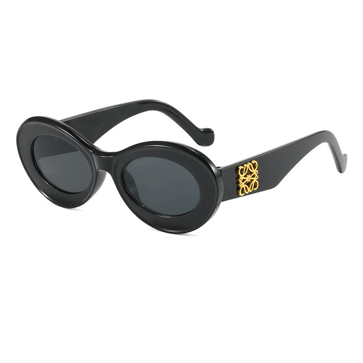 Dame moteriktig solbrille med oval ramme og gullapplikasjoner Skanto