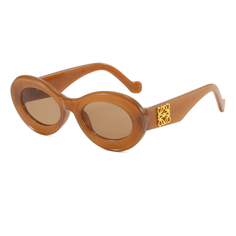 Dame moteriktig solbrille med oval ramme og gullapplikasjoner Skanto