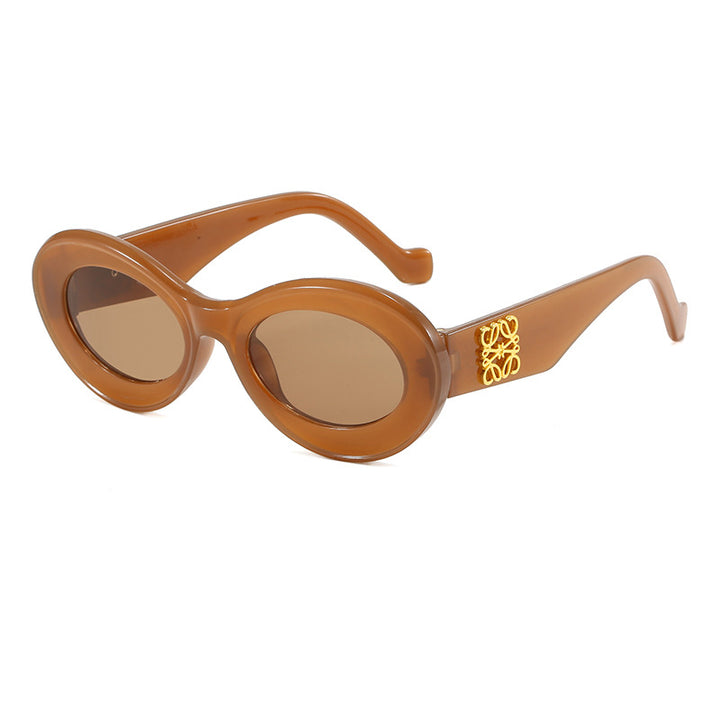 Dame moteriktig solbrille med oval ramme og gullapplikasjoner Skanto