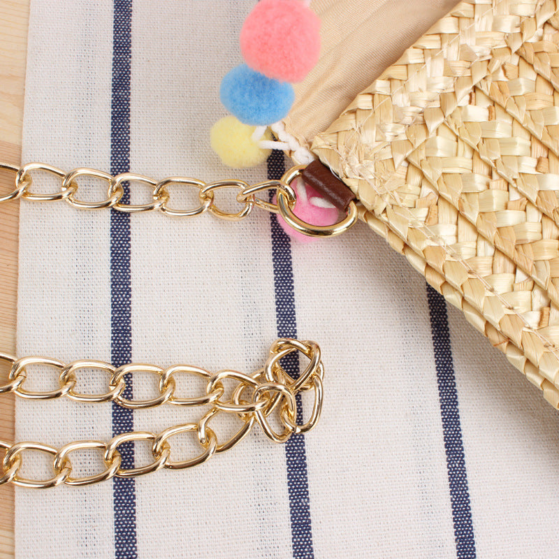 Hand-woven natural material clutch with decorative pom-poms Skanto