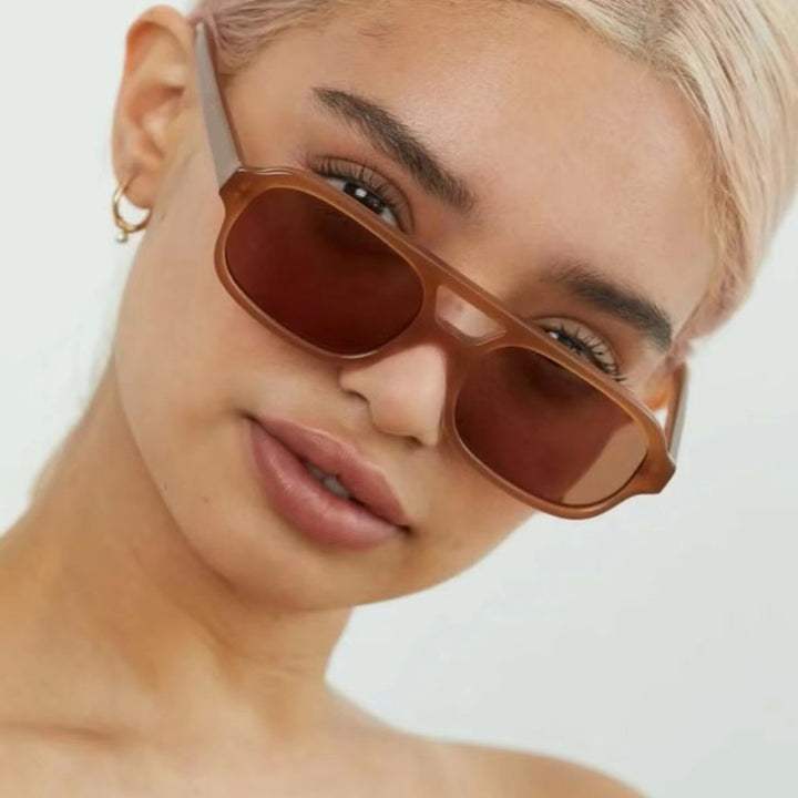 Dame moteriktig kvadratisk solbrille laget av transparent plast Skanto