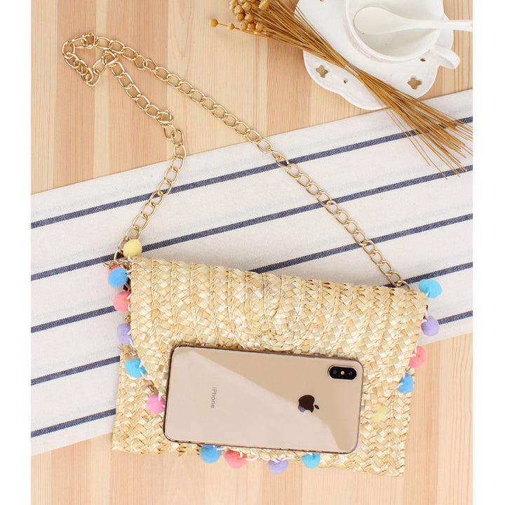 Hand-woven natural material clutch with decorative pom-poms Skanto