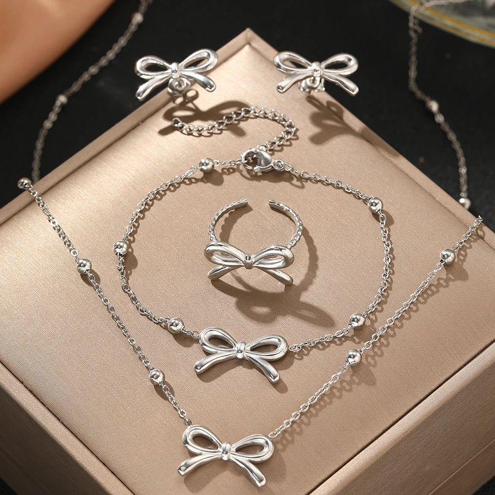 Skanto | Feminine Bow Satellite Chain Necklace, Bracelet, Earrings, and Ring Set