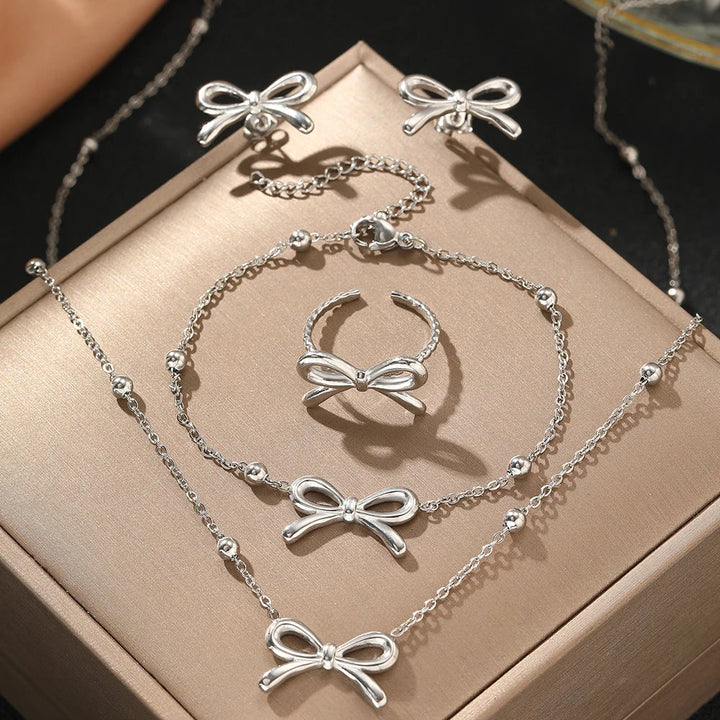 Skanto | Feminine Bow Satellite Chain Necklace, Bracelet, Earrings, and Ring Set