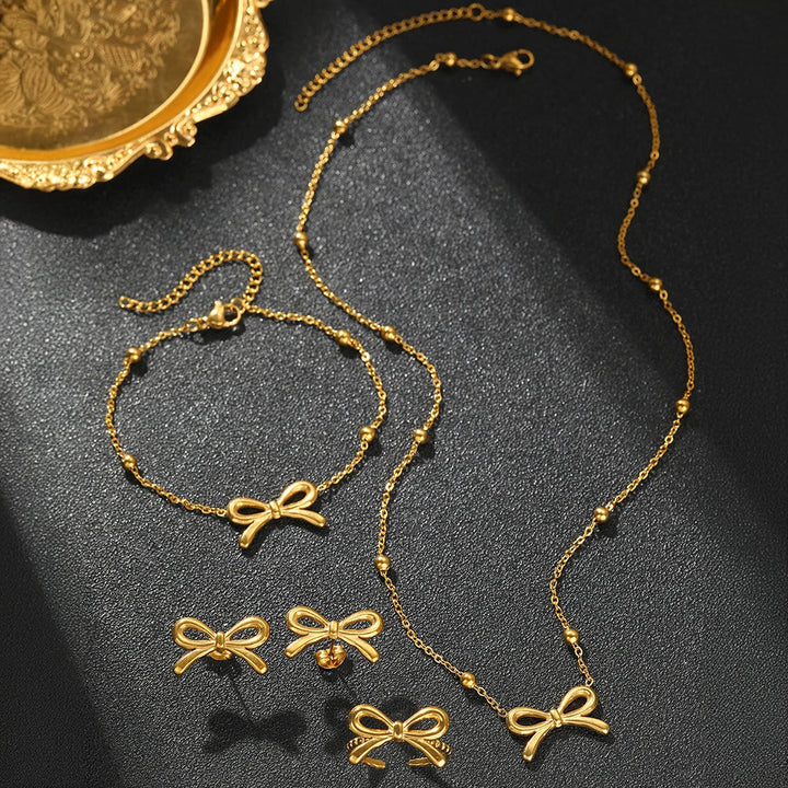 Skanto | Feminine Bow Satellite Chain Necklace, Bracelet, Earrings, and Ring Set