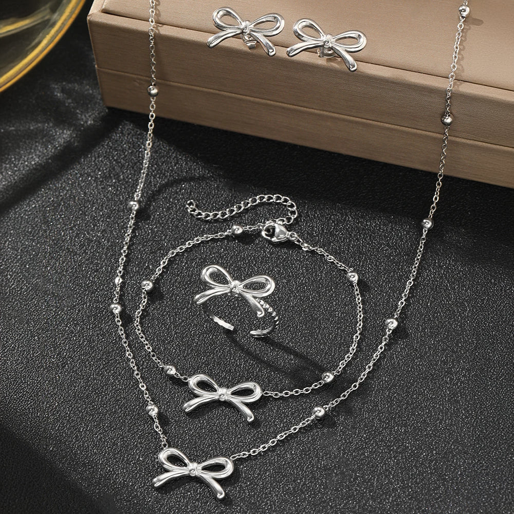 Skanto | Feminine Bow Satellite Chain Necklace, Bracelet, Earrings, and Ring Set