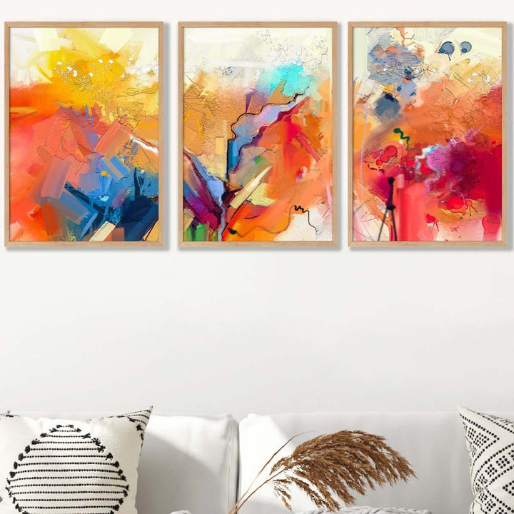 Abstrakt, fargerikt sett med tre veggkunstverk i oransje, rosa og rødt.